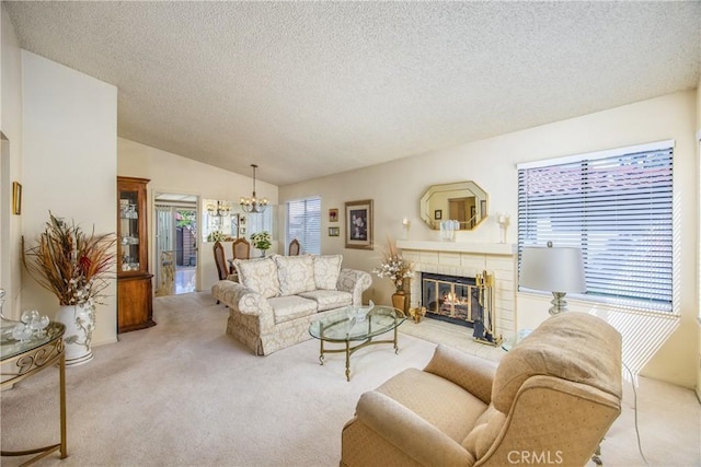 carpeted living area featuring vaulted ceiling, a textured ceiling, a fireplace, and a notable chandelier