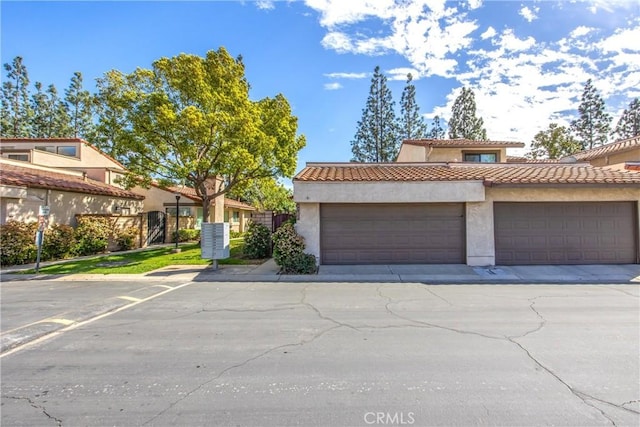 townhome / multi-family property featuring a tiled roof and stucco siding