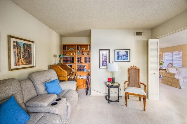 living area with visible vents, a textured ceiling, and carpet flooring