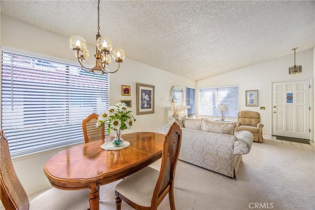 dining space featuring lofted ceiling, a textured ceiling, an inviting chandelier, and light colored carpet