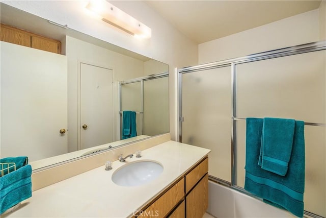 bathroom with combined bath / shower with glass door and vanity