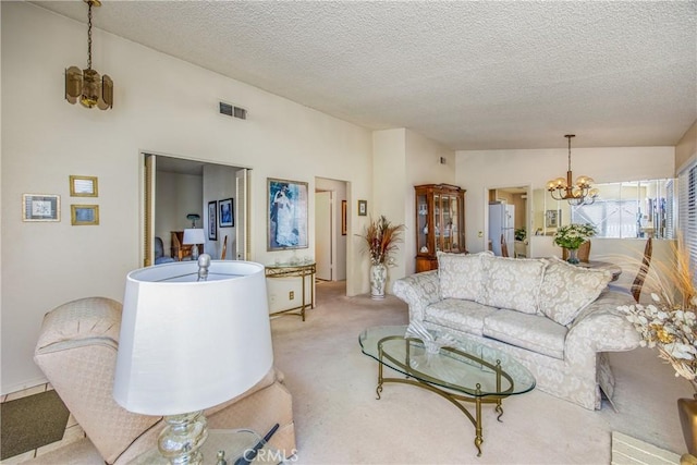 living area featuring light carpet, visible vents, vaulted ceiling, a textured ceiling, and a chandelier