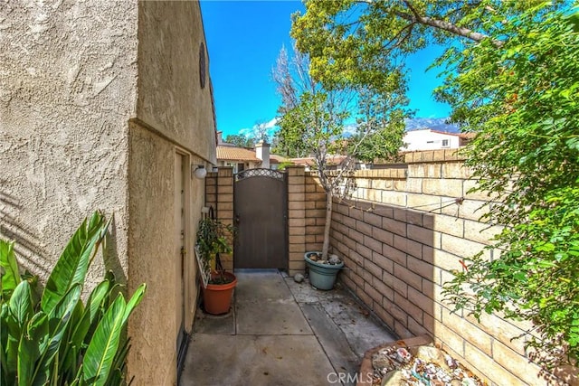 exterior space featuring fence, a gate, and stucco siding