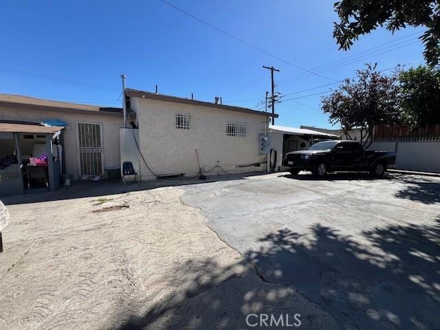 view of property exterior featuring fence and stucco siding