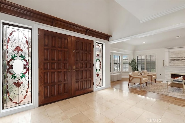 foyer featuring ornamental molding, recessed lighting, a fireplace, and baseboards