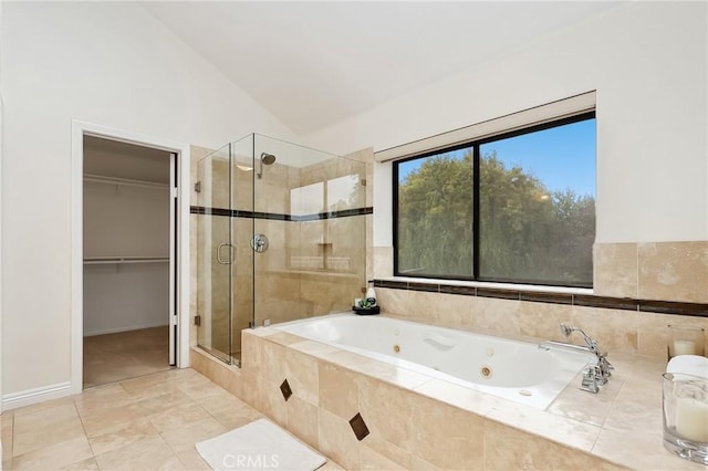 bathroom with lofted ceiling, tile patterned floors, a whirlpool tub, a walk in closet, and a shower stall