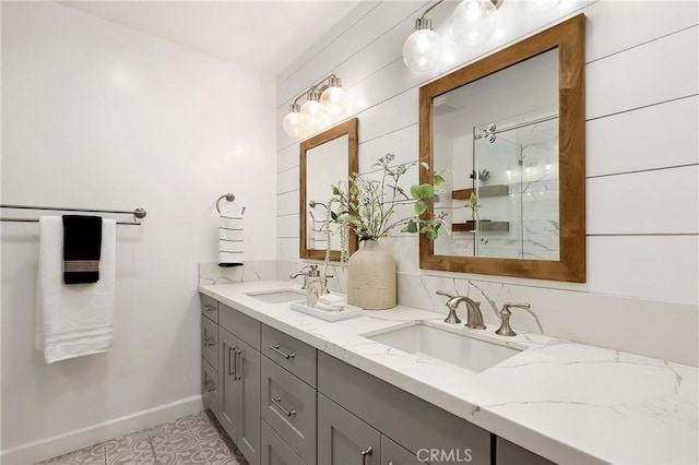 full bath featuring walk in shower, a sink, baseboards, and double vanity