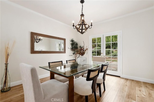 dining space featuring light wood-style floors, baseboards, and ornamental molding