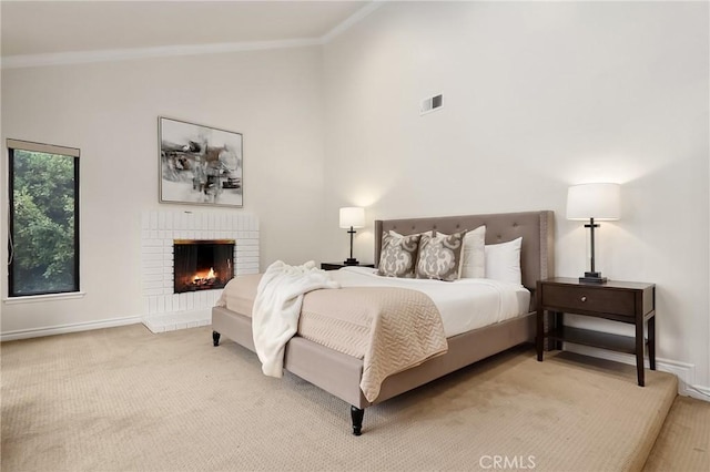 bedroom featuring light colored carpet, a brick fireplace, visible vents, and crown molding