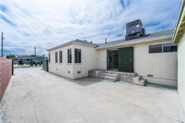 back of house featuring stucco siding, central AC unit, a patio, and crawl space