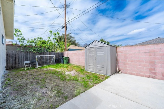view of yard featuring a fenced backyard, an outdoor structure, and a shed