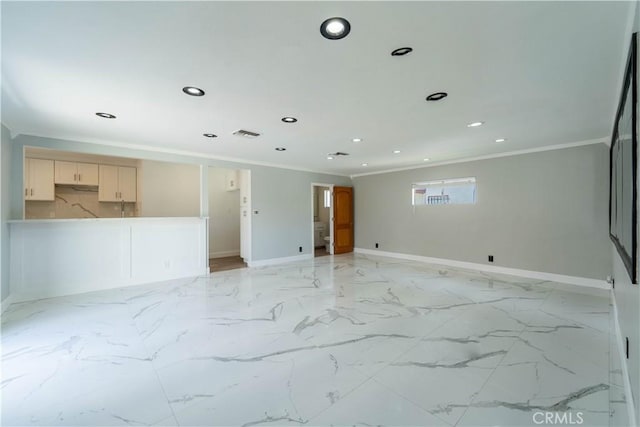 empty room featuring baseboards, ornamental molding, and visible vents