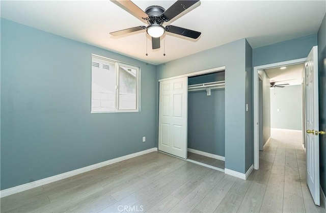 unfurnished bedroom with baseboards, a ceiling fan, a closet, and light wood-type flooring