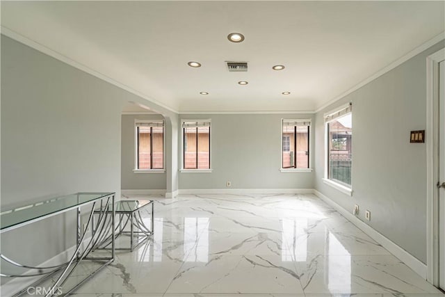 spare room with marble finish floor, ornamental molding, baseboards, and visible vents