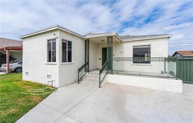 view of front of property featuring a gate, fence, crawl space, a front yard, and stucco siding