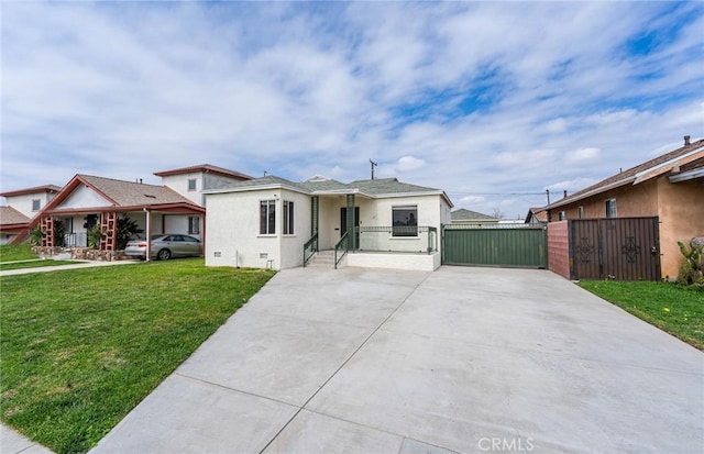 bungalow with driveway, a gate, a front lawn, and stucco siding