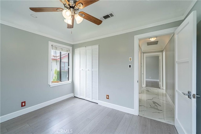 unfurnished bedroom with baseboards, visible vents, and crown molding