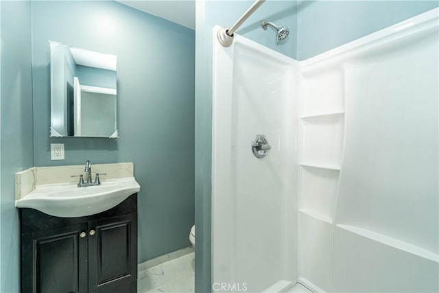 full bathroom with marble finish floor, toilet, a shower, and vanity