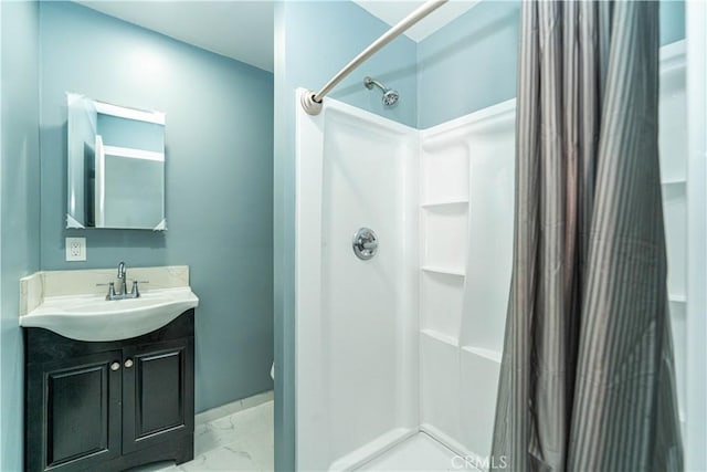 bathroom featuring marble finish floor, a shower with shower curtain, and vanity