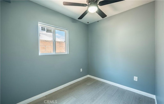 empty room with baseboards, ceiling fan, and wood finished floors