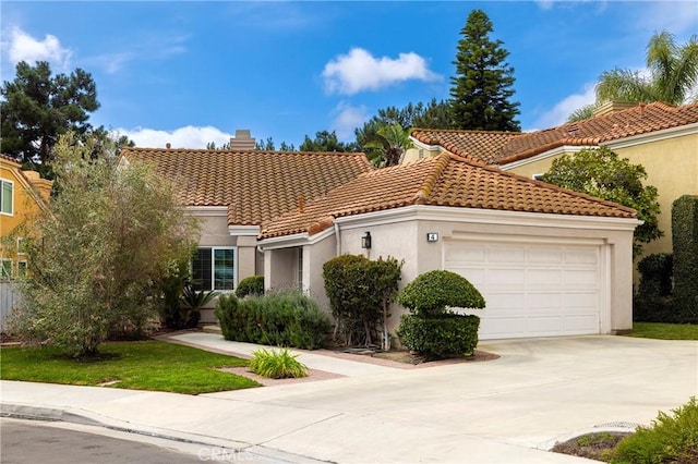 mediterranean / spanish house with a chimney, stucco siding, an attached garage, driveway, and a tiled roof