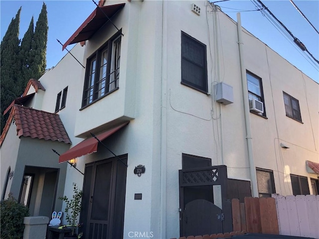 exterior space with stucco siding and a tile roof