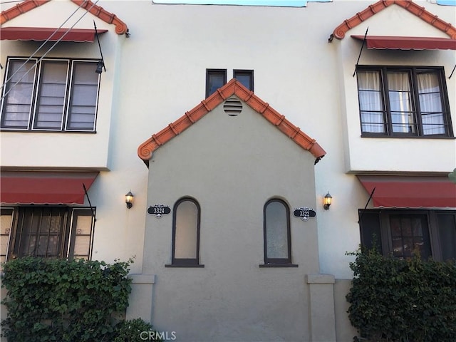 view of property exterior featuring stucco siding and a tile roof