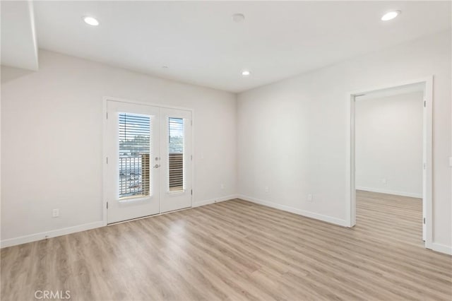 unfurnished room with baseboards, french doors, recessed lighting, and light wood-style floors