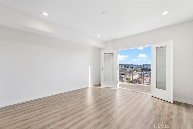 unfurnished room featuring baseboards, light wood-type flooring, and recessed lighting