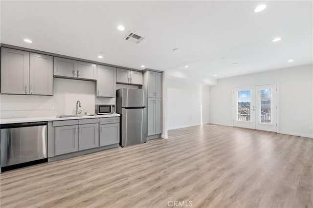 kitchen with stainless steel appliances, visible vents, a sink, and gray cabinetry