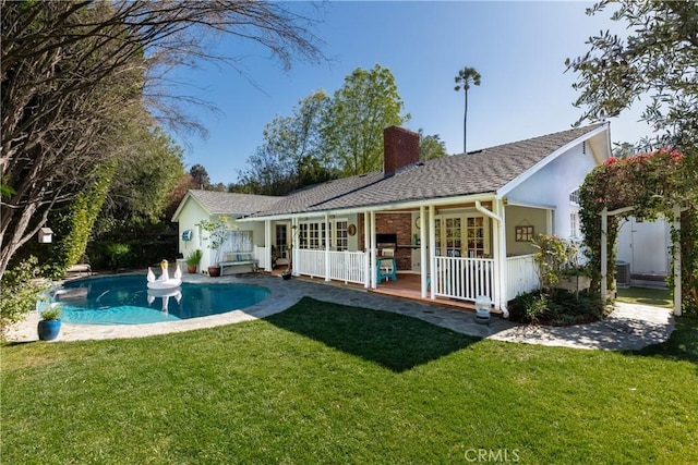 back of house with french doors, a yard, a chimney, central AC unit, and an outdoor pool