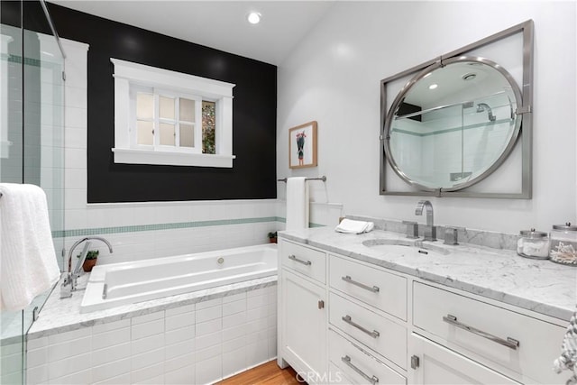 full bath featuring a garden tub, a shower stall, and vanity