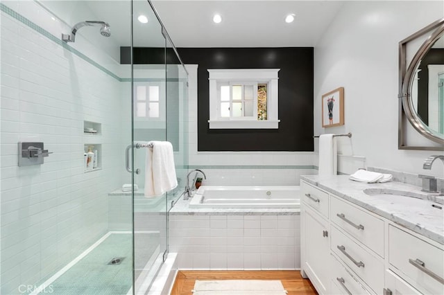 full bathroom featuring vanity, a shower stall, a bath, and recessed lighting