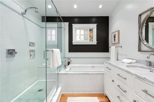 bathroom with vanity, recessed lighting, a bath, and a shower stall