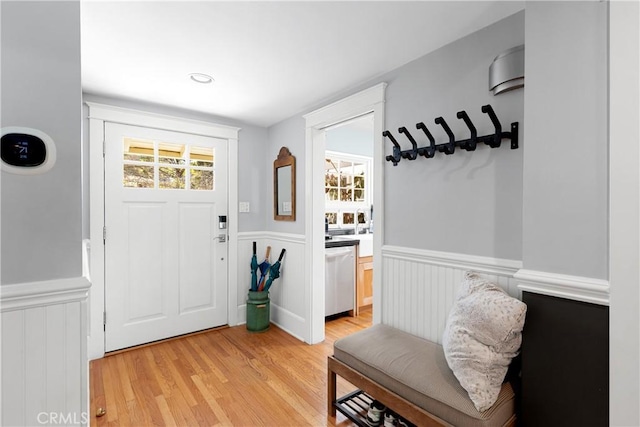 interior space with light wood finished floors and a wainscoted wall