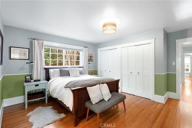 bedroom with light wood finished floors, multiple windows, and baseboards