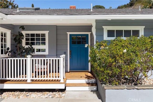 property entrance with a porch and a shingled roof