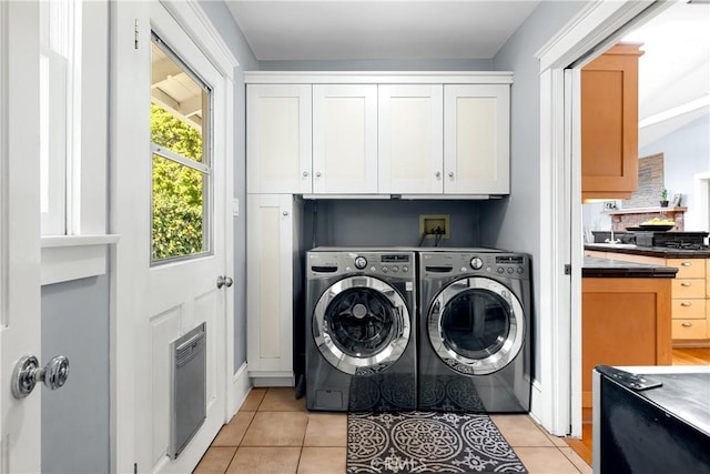 laundry area featuring washing machine and dryer and light tile patterned floors