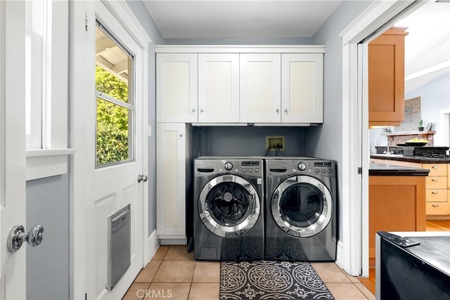 washroom with washer and clothes dryer and light tile patterned floors