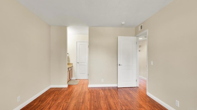 unfurnished bedroom featuring light wood-style floors, visible vents, and baseboards