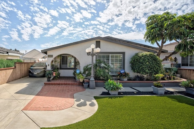 rear view of property with fence, a lawn, and stucco siding