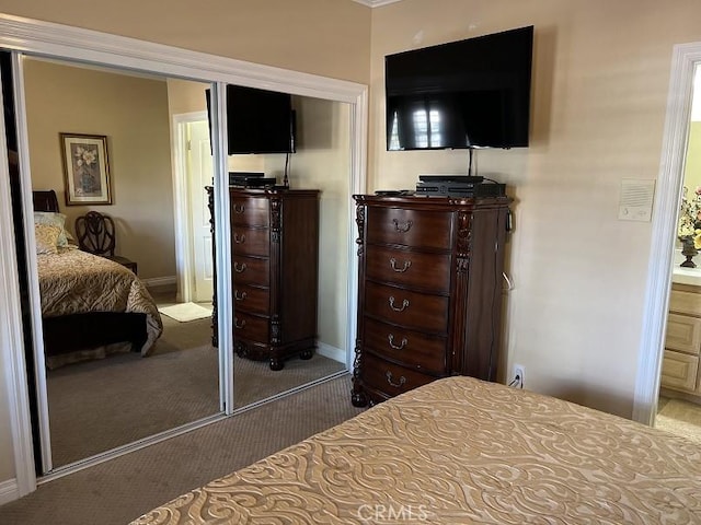 carpeted bedroom with baseboards and a closet