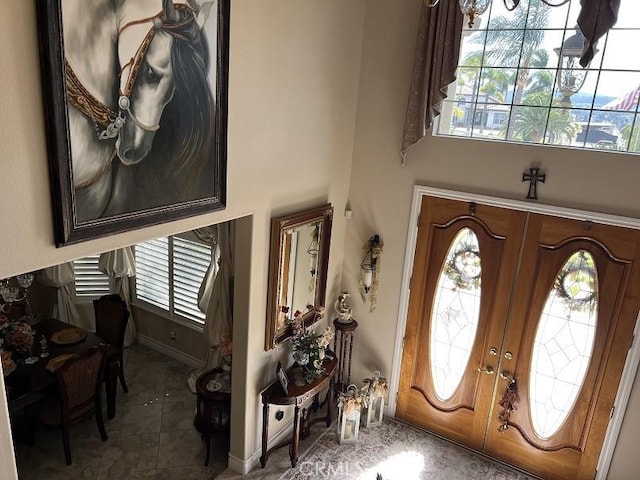 tiled foyer entrance with french doors and baseboards