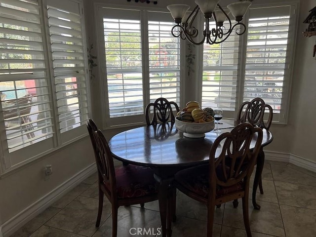 dining area with baseboards, a notable chandelier, and tile patterned floors