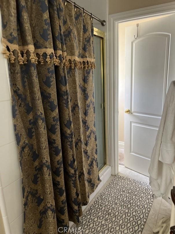 bathroom featuring tile patterned flooring and a shower stall