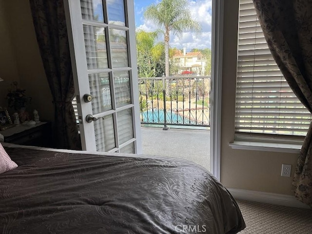 bedroom featuring multiple windows, carpet, and baseboards