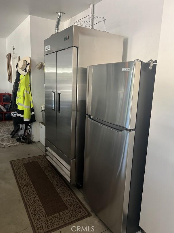 kitchen featuring high end fridge, concrete floors, and freestanding refrigerator