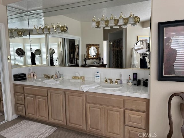 full bath featuring a sink, decorative backsplash, and double vanity