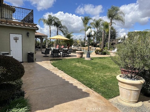 view of yard featuring a balcony and a patio area