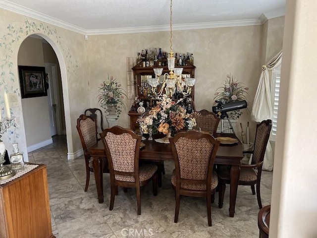 dining room featuring ornamental molding, arched walkways, a notable chandelier, and baseboards